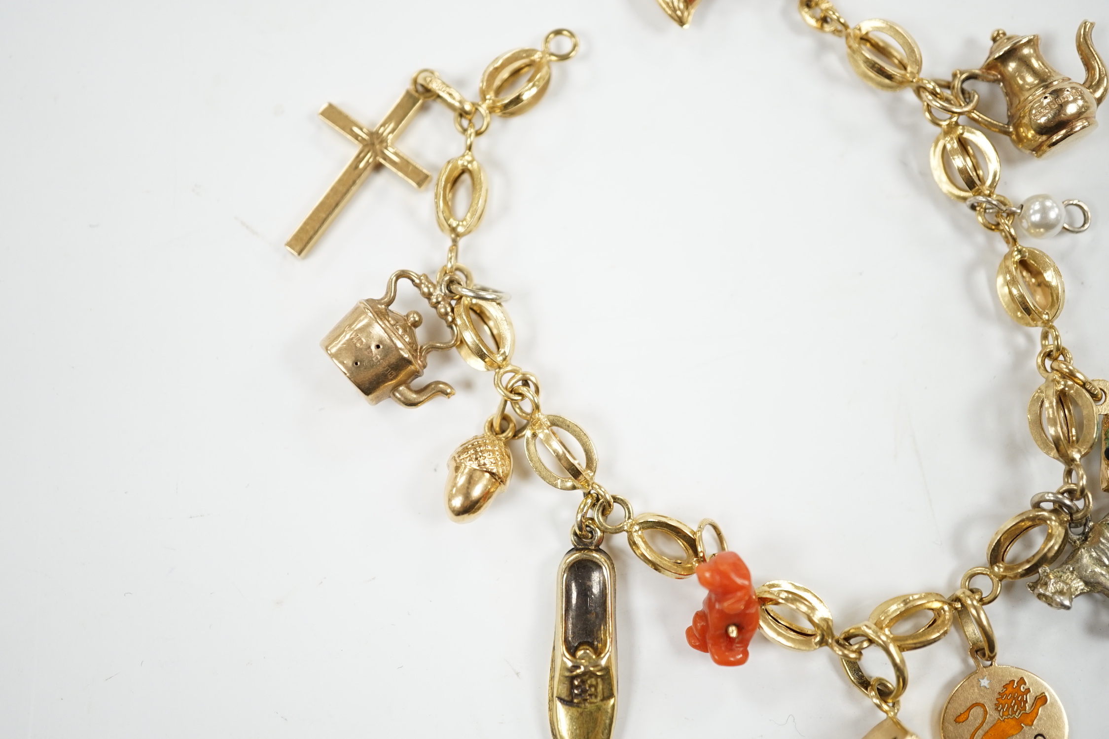 An Italian 750 charm bracelet, hung with eleven assorted charms including 9ct, yellow metal and 800 standard white metal